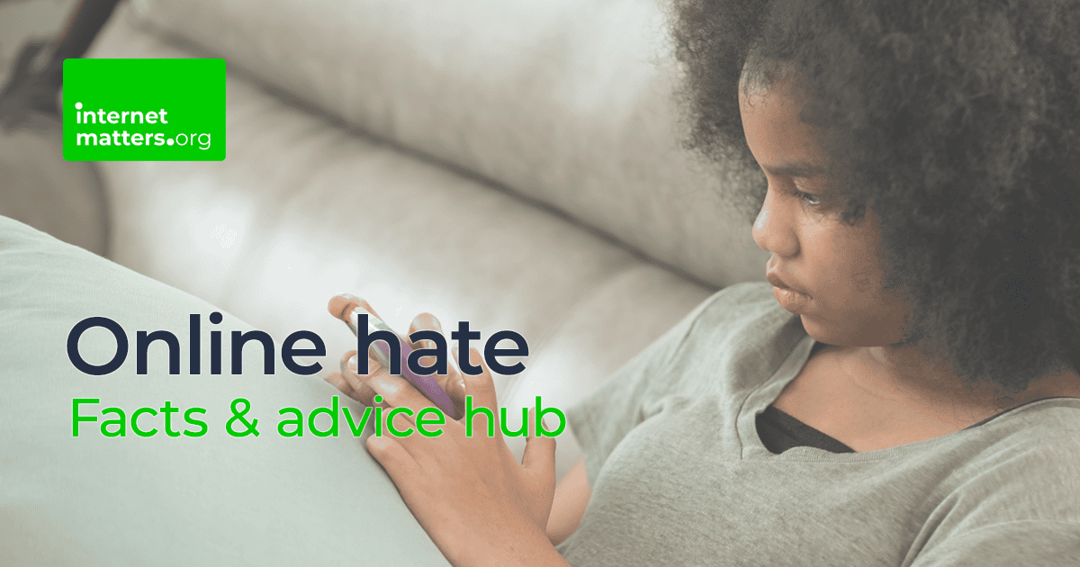 Preteen girl sitting on a sofa with a serious look on her face as she looks at a multicoloured device in her hands. Text reads 'Online hate: Facts and advice hub' with the Internet Matters logo.
